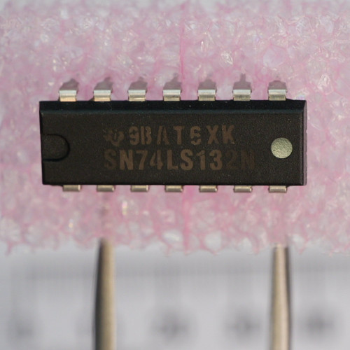 Close-up of Texas Instruments SN74LS132N 14-pin DIP integrated circuit on foam.