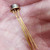Dual transistor with gold-plated leads in bright hermetic metal can, held in open palm
