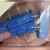 Four blue trimmer potentiometers, two with legible 3006P-1-102 markings, held in an open palm