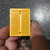 Yellow 170 tie-point mini solderless breadboard held in a hand, showing its compact 1.5 x 1.75 inch size.