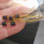 Five black TO-1 metal can units with gold leads; partial markings 2N228 visible on bodies; red dot visible on two units.