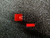 Two unused rectangular red diffused LEDs; leads straight and undamaged on the taller unit, shorter unit shows leads trimmed.