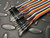 40-piece male-to-male breadboard jumper wire ribbon with multi-colored wires and black connectors.