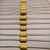 SA305C334MAA axial ceramic capacitors with yellow coated bodies mounted on tape.