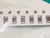 Six mid brown chip capacitors in paper carrier tape, green mat corner top right