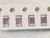 Four dark brown mauve chip capacitors with speckled silver terminations in tape pockets