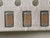 Macro of three tan ceramic chip capacitors with silver end caps in tape