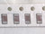 Four brown chip capacitors in carrier tape seen through wrinkled bag film