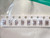 Length of tape holding eight brown ceramic capacitors, green mat corner behind