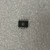 Black SOIC-8 package, leads unformed. Circular logo mark visible on top face.