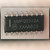 Motorola MMPQ2222A quad NPN transistor array held on a fingertip, top marking visible