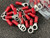 Red-insulated ring terminals with silver barrel crimp ends and circular eyelets; approximately 20 units loose, more in bag behind.