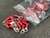 Red vinyl-insulated ring terminals with closed barrels, approximately 50 pieces shown loose and in a clear plastic bag.