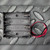 Black plastic 4-cell AAA holder molded with 1.5V polarity markings per slot, coil springs visible, bare red and black wire leads attached.