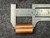 Copper oval sleeve measured against General-brand calipers at approximately 30mm length, uniform warm copper tone, no oxidation or deformation visible.