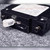 Angled corner view of black molded case, white 10A handle, side mounting screw