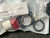 Factory-sealed bag with "pub17978 Revision J" label visible; red lens indicator, mounting hardware, and black bezel ring all present.