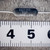 Close-up of Tepro TS1 100 ohm 0.1% precision axial resistor showing markings next to a ruler.