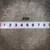Full view of a Tepro TS1 100 ohm axial resistor with long straight leads against a metric ruler.