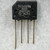 Black molded SIP-4 body marked TAIWAN, 9003, 2KBP02M, GI 3N255; + and - polarity symbols visible. Four leads show light oxidation.