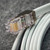 Obtainium RJ12-6P6C-94 connector end showing gold contact pins and metal shield.