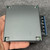 Hand holding EWS15-12 showing perforated bottom edge, mounting bracket and case screw
