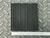Top-down view of the DiversiTech MP-4E Anti-Vibration Pad from PartsMine.com with vertical ribs and a ruler at the bottom showing scale, placed on a diamond plate surface.