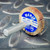 Shank side perspective of Merit 08834137602 120-grit flap wheel on metal surface.
