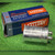 Mallory CG42U100A1 capacitor standing in front of its open blue and orange Mallory carton
