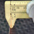 Caliper measuring the edge thickness of a PartsMine 12x12-010-HHHH copper clad laminate board.