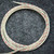Coiled cream braided lead wires with red tracer, cut ends slightly frayed.