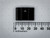 Front view of black TO-220 clip-on heatsink, two folded wings, against millimeter ruler scale