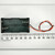 Black plastic 2x2 stacked holder marked UM-3X4 with polarity symbols, four coil-spring contacts visible, red and black lead wires; body spans approximately 57mm per ruler.
