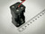 Side view of a black plastic 4 AA battery holder with exposed spring connectors, output leads, and a ruler beside it indicating its dimensions. Available at PartsMine.com.