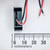 Side profile of 9V battery snap connector body against a millimeter ruler.