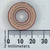 Top view of Hypertherm 220179 swirl ring with laser markings next to a millimeter scale.