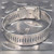 Back of hose clamp band showing worm gear buckle and screw slot