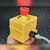 Yellow Allen-Bradley push button enclosure held in hand, cord grip and grey cable stub at side