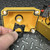 Hand holding black 800F latch collar beside the open yellow enclosure lid interior