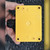 Underside of yellow Hibox ABS enclosure base with molded dimension marks, made in Korea