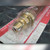 Brass-toned seat end of Koike tip with stepped lands and small drilled ports