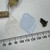 Clear TO-3 insulating washer, blue silicone thermal pad and two black mounting screws with ruler