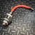 Stud-mount SCR body with threaded stud and hex nut, red wire lead with stripped end and ring terminal. Minor surface marks visible.
