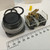 Angled view of Allen-Bradley 800H-AR2 black push button beside clear 800T-XD1 contact block with brass terminals