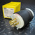 Hubbell HBL2521 Twist-Lock Plug 20A 277/480V 4P 5W Insulgrip from PartsMine.com shown in front of its yellow retail box, both placed on a textured black metal surface.