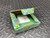 Opened Phoenix Contact carton with the green isolator module resting inside the box