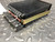 Side view showing brass panel mounting strap and caution label on black case
