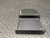 Bottom panels of two COM200 modems in brushed black anodized aluminum with corner screws