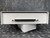 White metal enclosure with 100-pin SCSI-style connector centered on the front edge; two Phillips screws secure the connector. No visible damage.