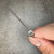 Close-up of fuse end cap held in fingers showing LITTELFUSE stamp around rim